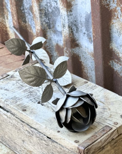 Vacker ros snitt ros i järn och metall med stor utslagen ros, lång stjälk många blad. Går i en zink går nyans med rost inslag. H