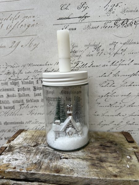 Ljusstake med vinterlandskap i snö