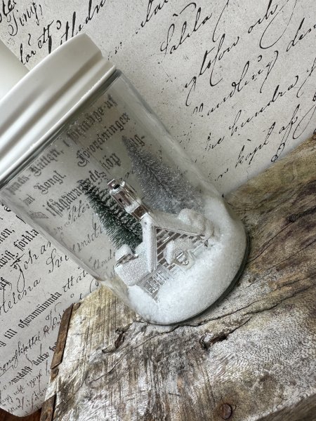 Ljusstake med vinterlandskap i snö