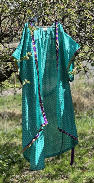Vacker indisk kimono i turkosa nyanser. Tillverkad i vackert återvunnet tyg från Indiska kvinnors sarier säljes i förmån att stä