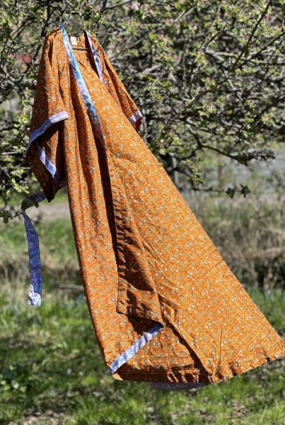 Vacker indisk kimono i orangea nyanser. Tillverkad i vackert återvunnet tyg från Indiska kvinnors sarier säljes i förmån att st