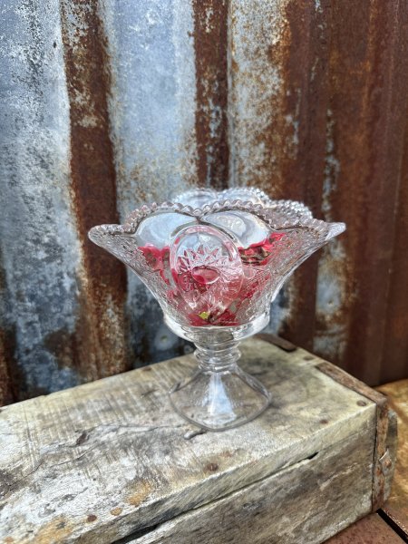 Vacker skål på fot i glas med mönster och vågad kant