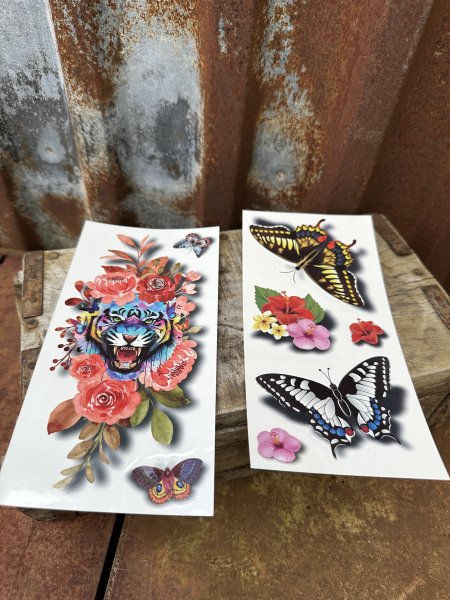Tatuering med blandade motiv av blommor, djur mm