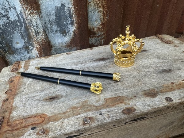 Krona i guld penna, pennvässare och bokmärke 