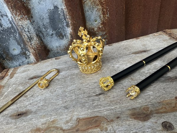 Krona i guld penna, pennvässare och bokmärke 