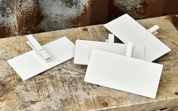 Vit skylt med klädnypa 