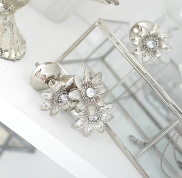 Vacker och elegant silverfärgad metall knopp formad som en blomma. Med fina detaljer och snygga drag. Dekorerad med en diamant f