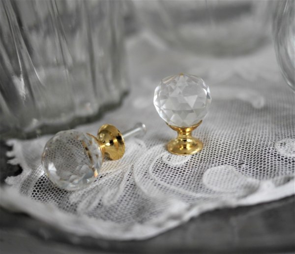 Vacker rund glas knopp i diamant modell. I rundad modell med guldfärgad stomme. Slipningarna reflekterar ljuset på ett vackert o