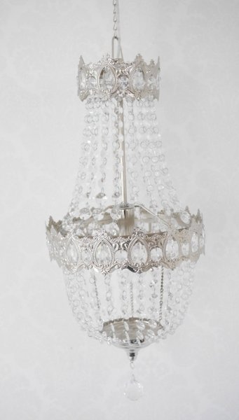 Vacker kristallkrona lampa i elegant modell med flera rader av prismor i olika variationer. Prismorna är i plast men ger sken av