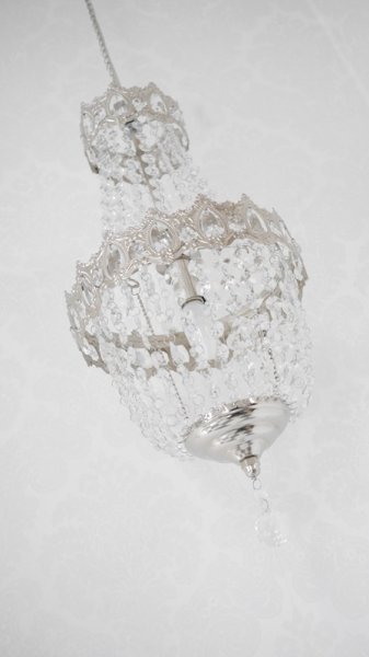 Vacker kristallkrona lampa i elegant modell med flera rader av prismor i olika variationer. Prismorna är i plast men ger sken av