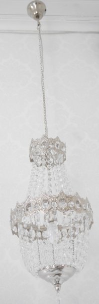 Vacker kristallkrona lampa i elegant modell med flera rader av prismor i olika variationer. Prismorna är i plast men ger sken av