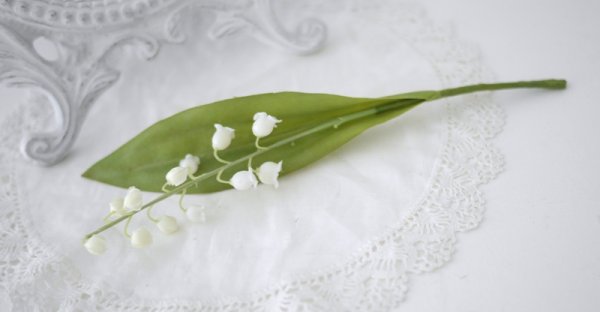 Vacker vit vår blomma Liljekonvalj med blad. Verklighetstrogen och välarbetad konstblomma. Passande att sätta i en mindre flaska