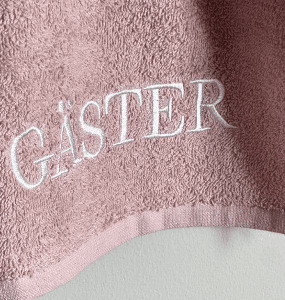 Rosa GÄSTER handduk med broderad text