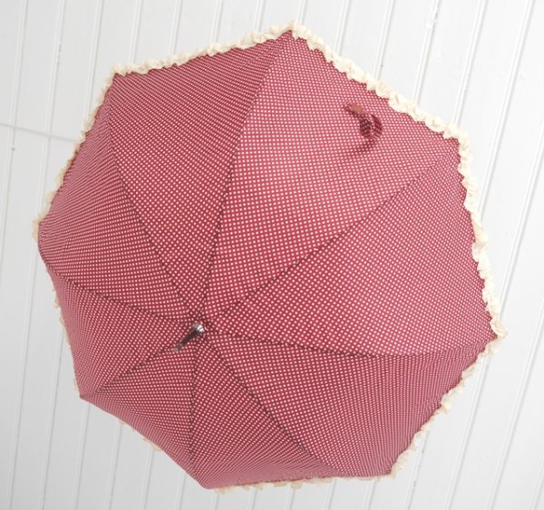 Vackert prickigt paraply i romantisk gammeldags stil, dekorerad med volang runt om samt en liten rosett vid handtaget. Finn i tr