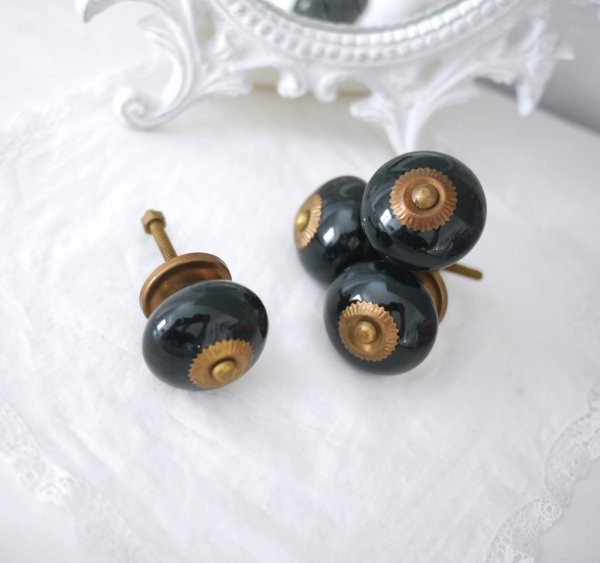 Svart keramik/porslins knopp med antikguld stomme